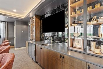 A modern kitchen with a large island and a flat screen TV mounted above it.